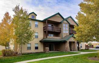 A large two story building with a green roof and balconies.