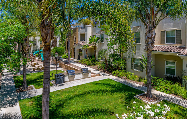 A sunny day in a residential area with apartment buildings and a well-kept garden.