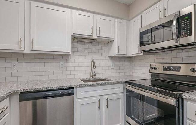 a kitchen with white cabinets and a stove and a microwave