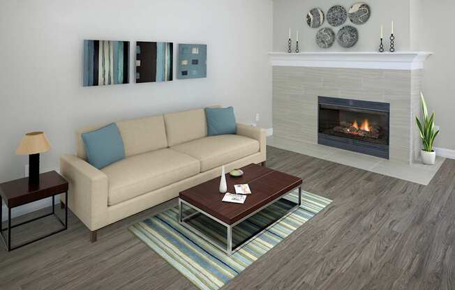 A living room with a beige couch, a fireplace, and a painting on the wall.