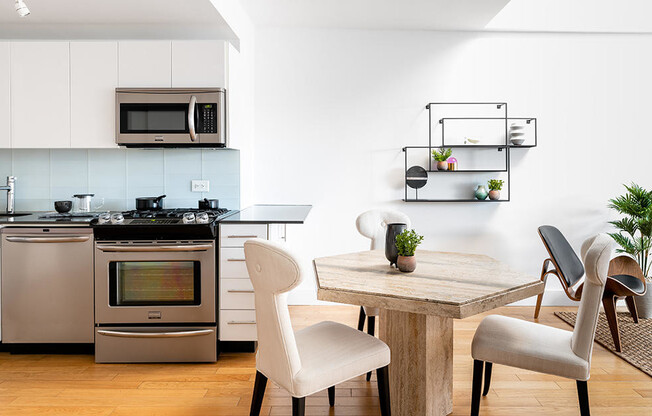 large penthouse kitchen and dining room with stainless steel appliances, wood floors, and skylights 