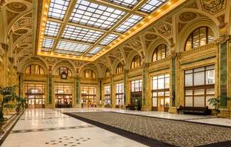 A large, ornate room with a high ceiling and a marble floor at The Pennsylvanian Apartments, Pittsburgh