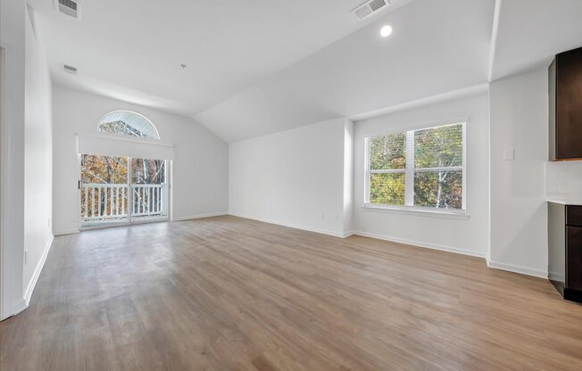 an empty living room with white walls and a sliding glass door