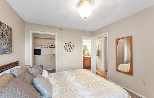 A bedroom with a large bed and a mirror on the wall.