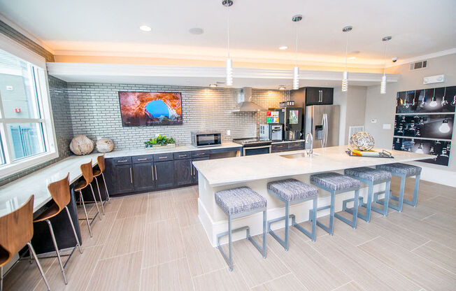 a large kitchen with a long counter and chairs