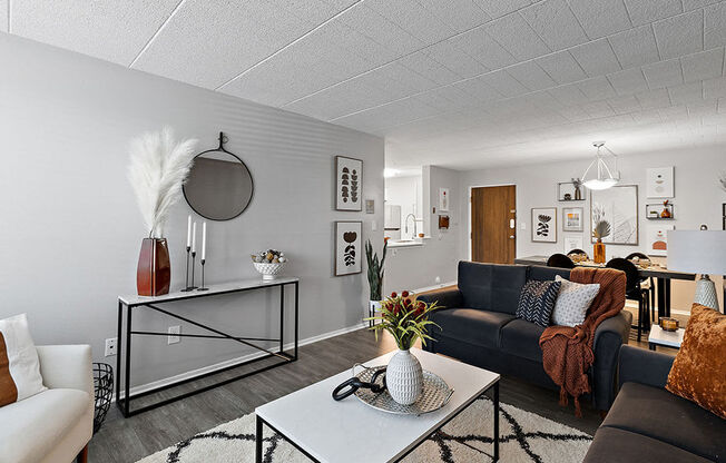 A living room with a black couch and a white coffee table.