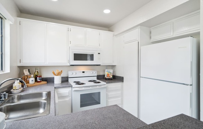 a white kitchen with white appliances and white cabinets