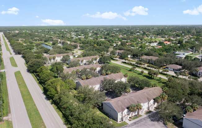A road runs through a green suburban neighborhood.