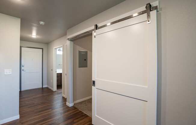 a bedroom with a white door and a hallway with a door to a bathroom. Fargo, ND 29 West Apartments