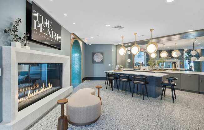 A modern living room with a fireplace and a kitchen area.