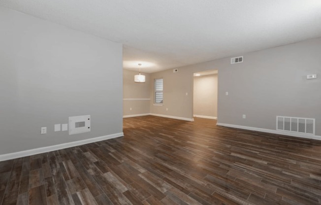 A room with wooden flooring and white walls.