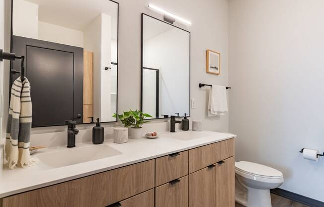 a bathroom with two mirrors and a sink and a toilet