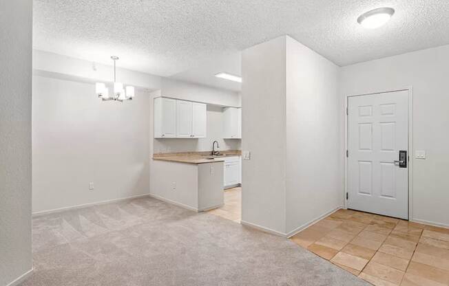 A spacious room with a kitchenette and a door. at Towers at Costa Verde Apartments, San Diego, CA