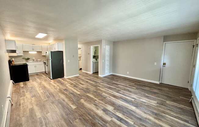 A room with a kitchen area and a dining table.