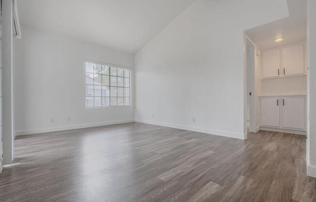 an empty living room with white walls and wood floors  at The Resort at Encinitas Luxury Apartment Homes, California