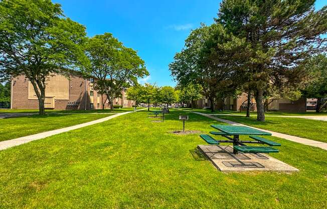 Expansive green space with picnic area at Woodland Villa Apartments in Westland, MI.