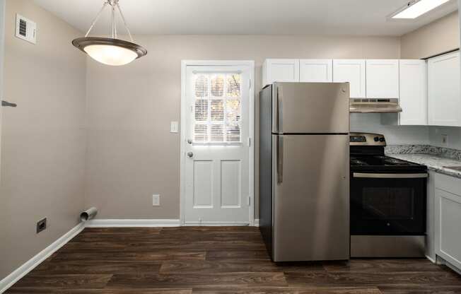 a kitchen with white cabinets and a stainless steel refrigerator