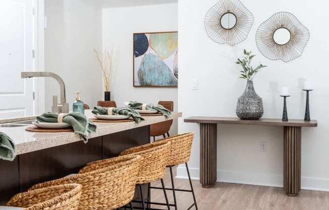 A kitchen with a table set for two and a painting on the wall.