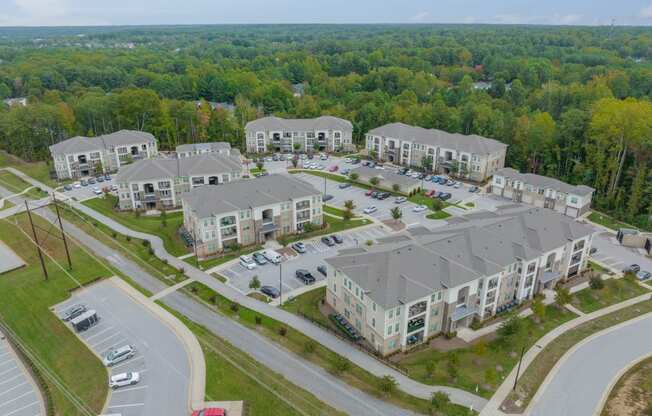 an aerial view of an apartment complex with cars parked in a parking lot
