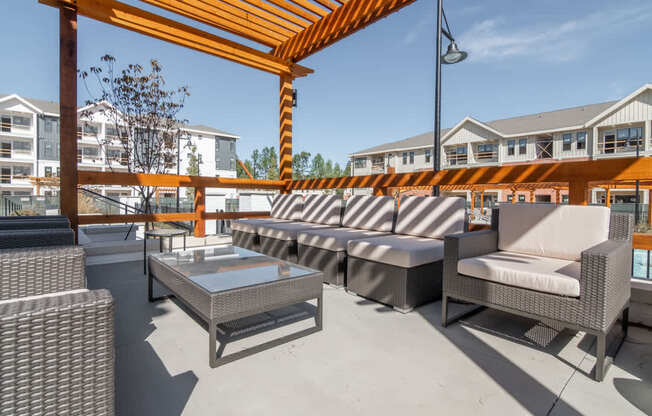 a patio with couches and tables and a glass coffee table