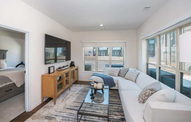 a living room with a white couch and a television at The Crossings at Windsong, Prescott Valley, AZ
