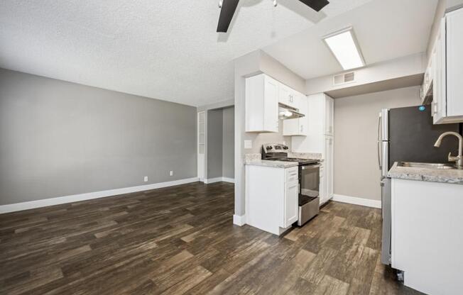 Model kitchen with a white fridge, stove, and oven.