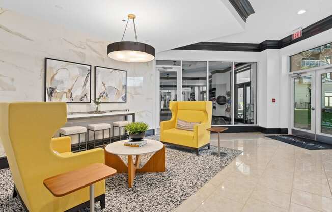 a lobby with yellow chairs and a table