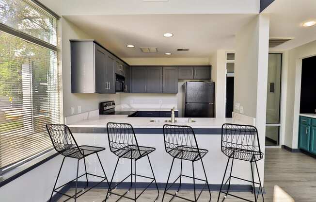 a kitchen with a counter and three bar stools