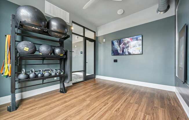 a fitness room with weights and a television on the wall at The Quarry Luxury Apartment Homes, Fort Collins, 80526