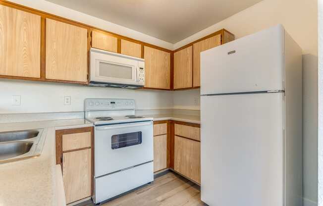 a kitchen with white appliances and wooden cabinets