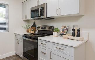 a white kitchen with a stove and a microwave