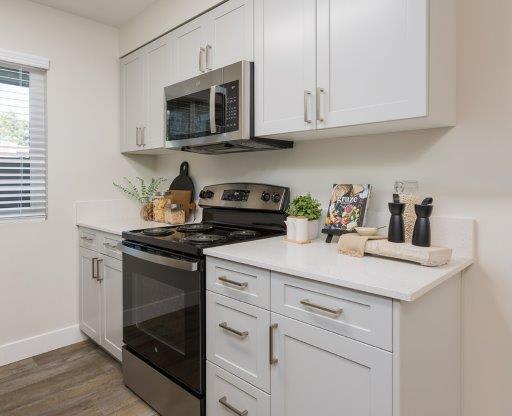 a white kitchen with a stove and a microwave