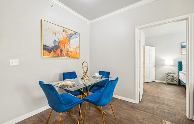 a dining room with a glass table and blue chairs