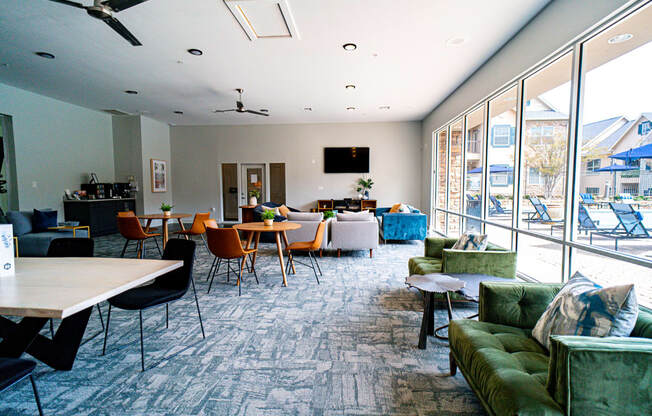 a large room with couches chairs and tables and a large window