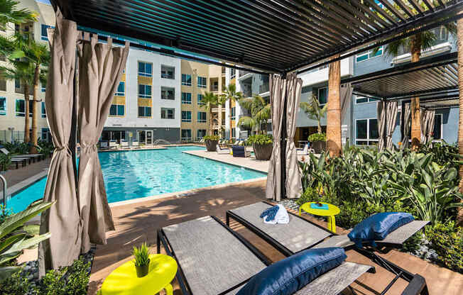 A poolside area with a yellow sun lounger and blue cushion.