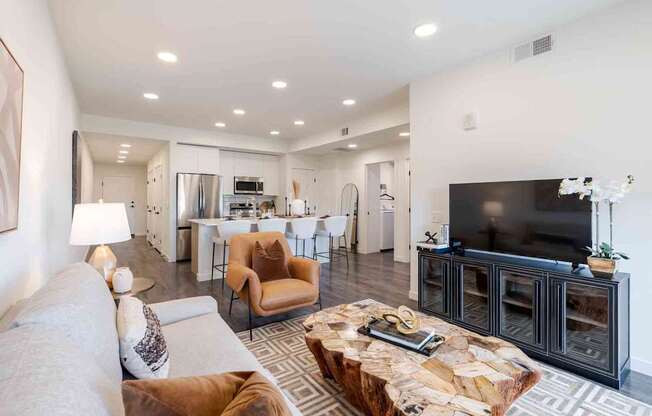 A modern living room with a stone coffee table and a flat screen TV.