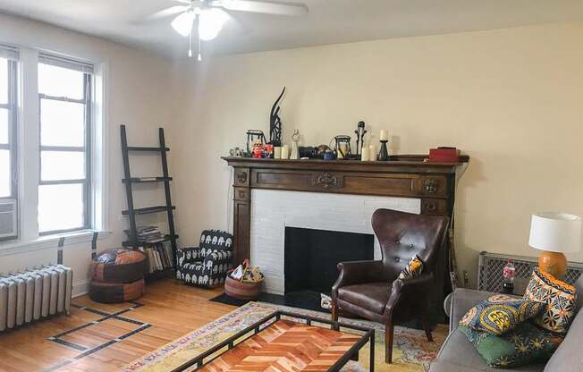 A living room with a fireplace and a brown leather chair.