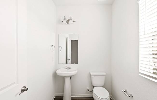 a bathroom with a toilet sink and mirror