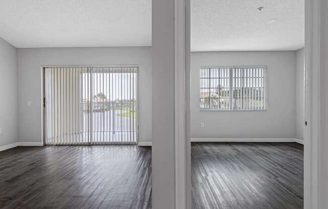 an empty living room with wood floors and a sliding glass door