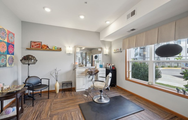 a living room with a table and chairs and a kitchen with a large window