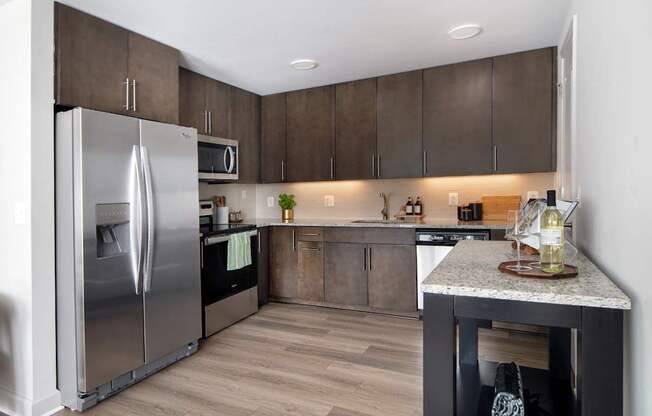 A modern kitchen with a stainless steel refrigerator and wooden cabinets.