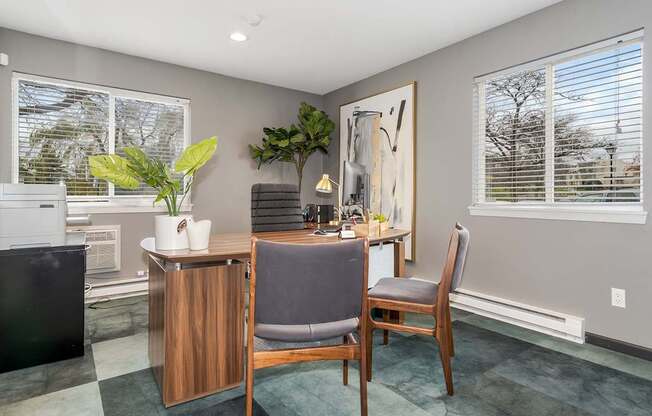 A room with a chair, a table, and a plant.