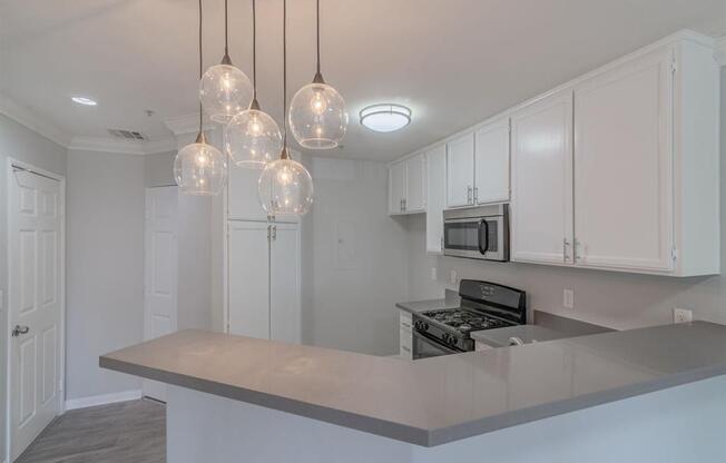 a kitchen with white cabinets and a counter top at Warner Center Townhomes, Canoga Park, CA 91303