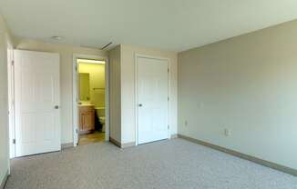 Carpeted Bedroom With Attached Bath at Pondside at Littleton Apartments.