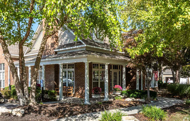 A house with a front porch and a tree in front.