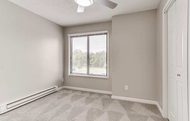 an empty room with white walls and a window