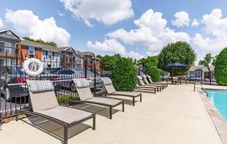 a row of lounge chairs next to a swimming pool