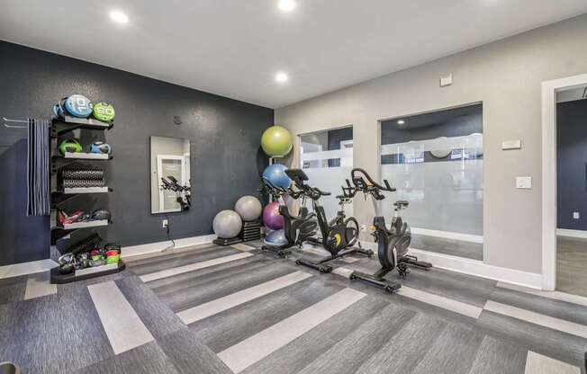 A room with a grey floor and a black wall with a white door and a white light switch.