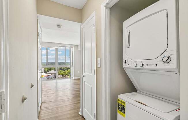 A white dryer is sitting in a laundry room next to a door.
