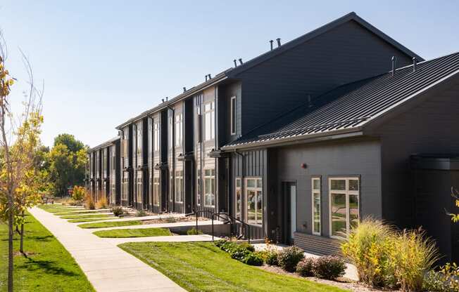 a row of houses with a sidewalk in front of them